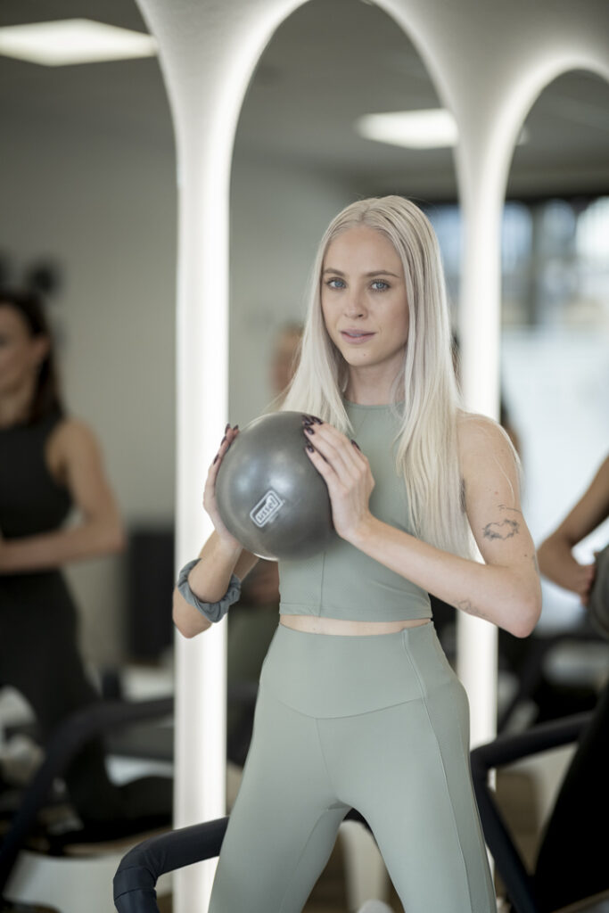 Teilnehmerin trainiert mit Pilatesball bei MALEA Reformer Pilates Bad Krozingen